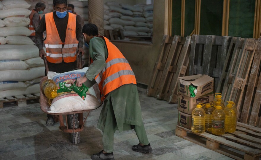 Wheelbarrows are loaded with oil, salt, flour and lentils at a WFP distribution center in Kabul.