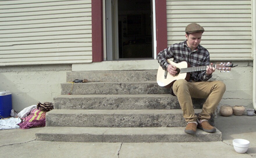 Bennett plays guitar on the porch.