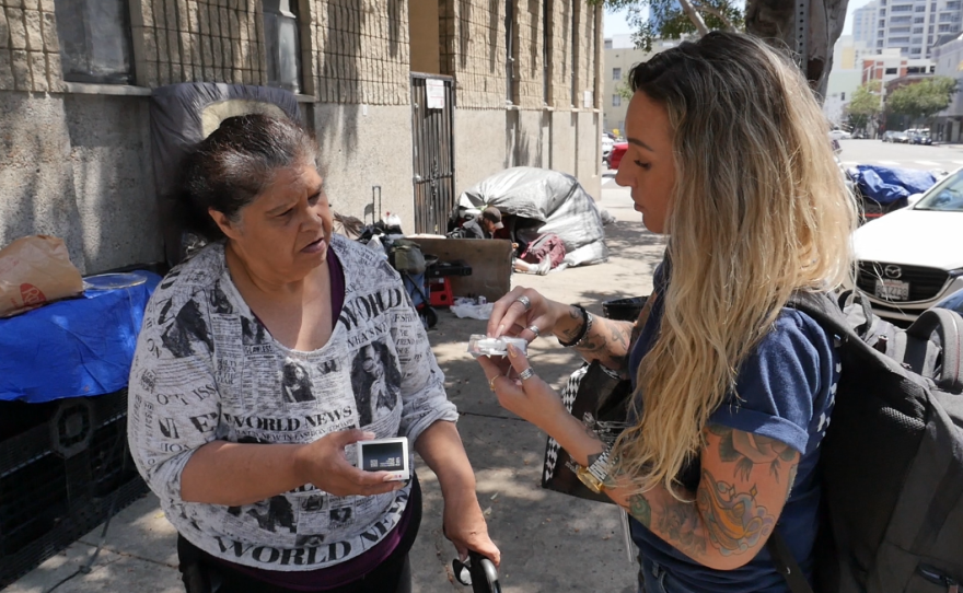 Father Joe's Villages Street Health Team supervisor Jennifer Wilkens shows an unsheltered resident how to use Narcan in downtown San Diego on Aug. 1, 2023.