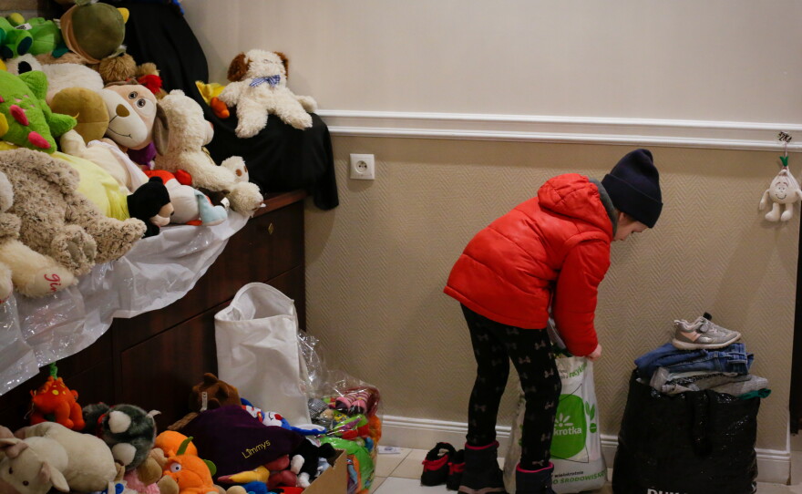 A young Ukrainian refugee traveling with her mother and sister searches for warm clothes and a few toys among the hotel's donated supplies.
