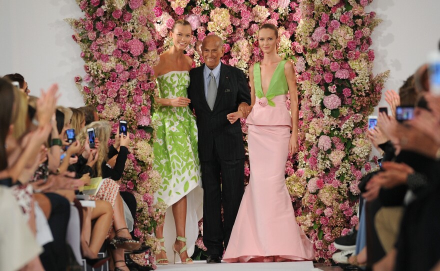 Designer Oscar de la Renta takes a bow with models Karlie Kloss, left, and Daria Strokous, right, after his Spring 2015 collection was modeled Sept. 9 during Fashion Week in New York. De la Renta died on Oct. 20.
