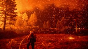 Embers fly above a firefighter as he works to control a backfire as the Delta Fire burns in the Shasta-Trinity National Forest, Calif., on Thursday, Sept. 6, 2018. 