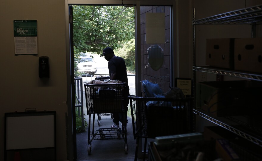 Jerry Leslie wheels a cart full of food to the waiting line of cars.