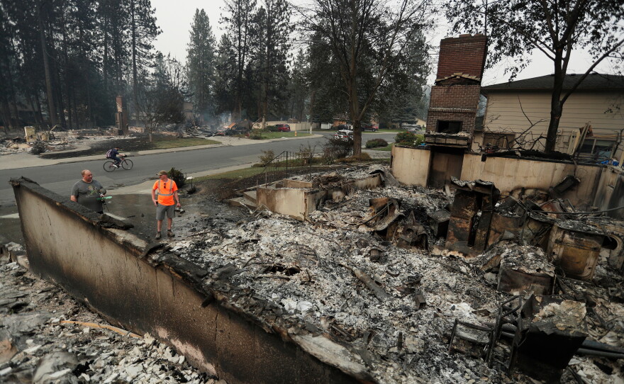 Chris Mutton, left, whose house burned in a wildfire speaks with Shane Maggart on Aug. 2, 2026, in Spokane, Wash.