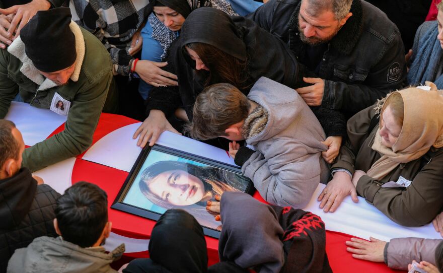 People mourn by a coffin during the funeral of Cypriot students killed in an earthquake that hit Turkey, in the eastern city of Famagusta, in the breakaway Turkish Cypriot statelet of northern Cyprus, on Feb. 11, 2023.