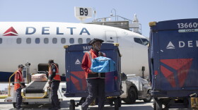 Delta Air Lines ramp agent Mike Davis prepares to load passenger luggage on his cart while working at Hartsfield-Jackson Atlanta International Airport, on May 13, 2026.