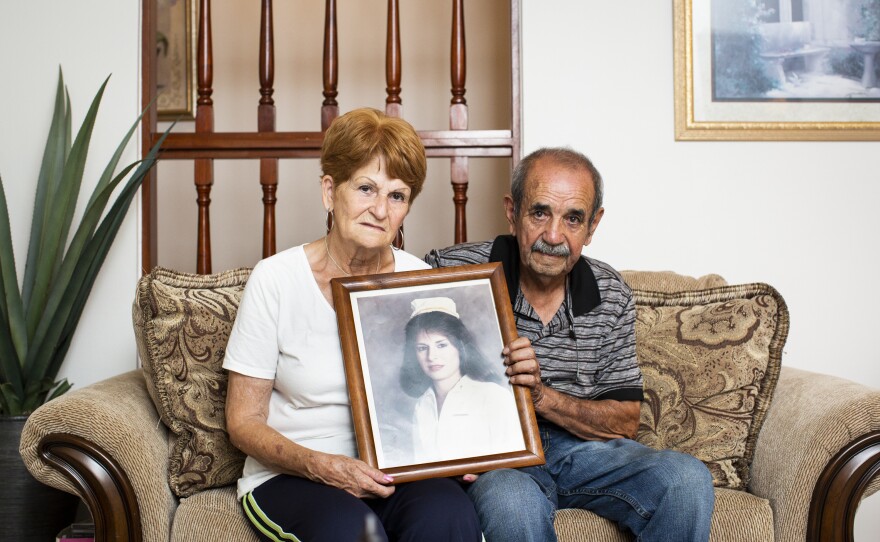 Nereida Maldonado, 74, and Sotero Viera, 80, hold a portrait of their daughter Madeline, who died 25 years ago. She was buried at the Lares Municipal Cemetery until January, when her parents had her remains exhumed and reburied 16 miles away.