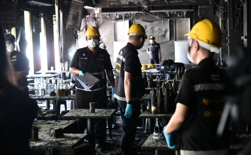 Rescuers carry the body of a victim of a fire in Bangkok, Thailand, Monday, July 13, 2026.
