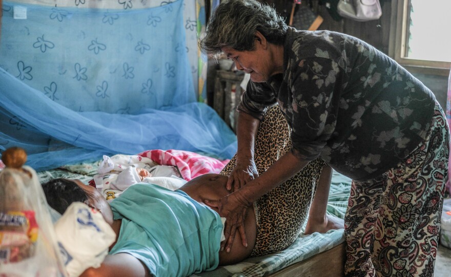 Florida Domingo massages Calibuso's belly. The early morning massage is part of a traditional healing process after delivery.
