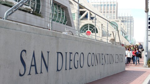 A group waits to cross Harbor Drive in front of the San Diego Convention Center. 