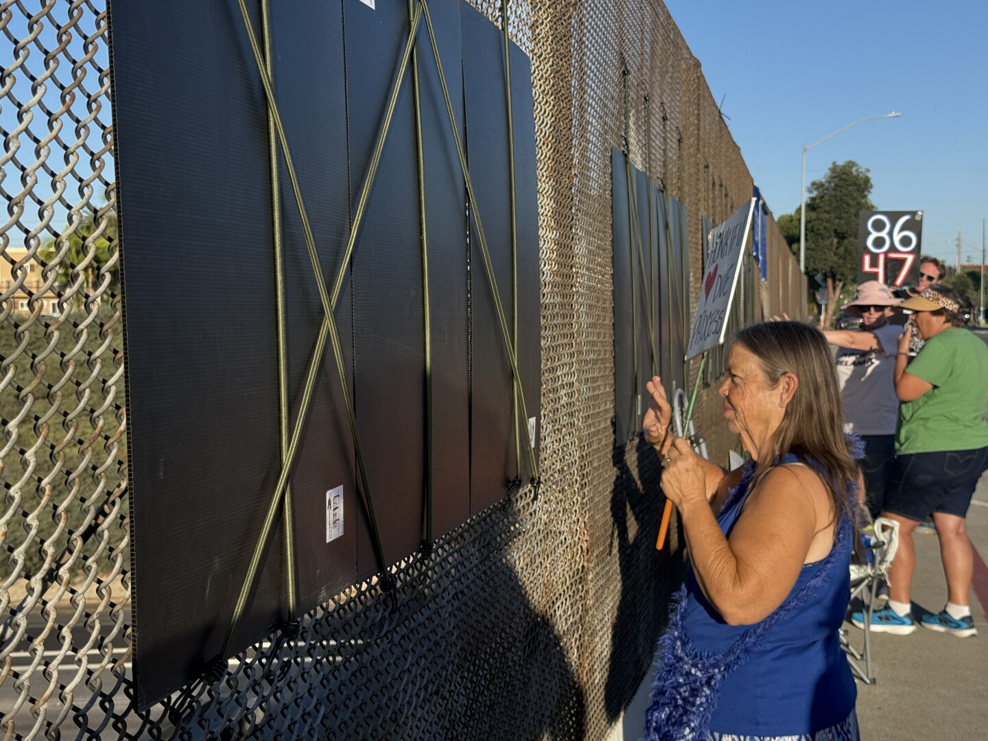 Ramona Konar waves to traffic on I-805 from the Meade Avenue bridge on Oct. 8, 2026.