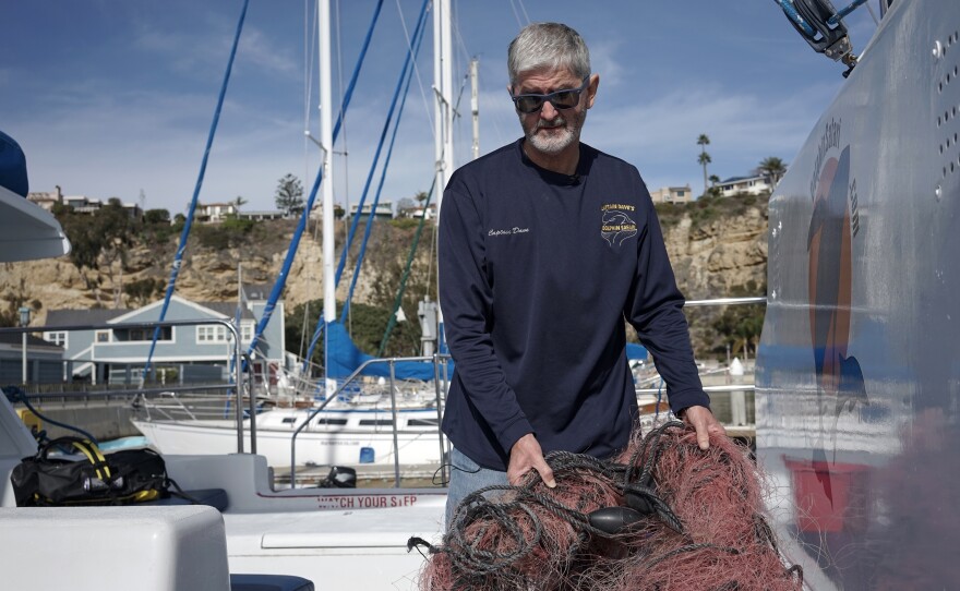 In this Monday, Nov. 30, 2015 photo, Capt. David Anderson of Captain Dave’s Dolphin and Whale Watching Safari in Dana Point, shows a net a whale was found entangled in.