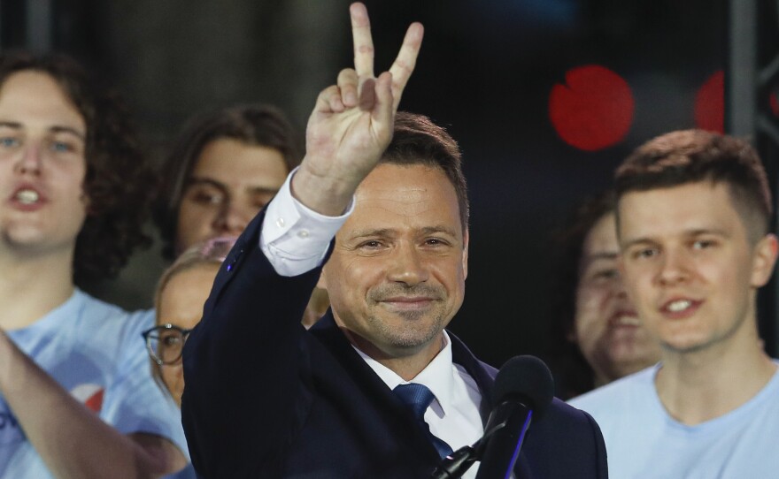 Presidential candidate and Warsaw Mayor Rafal Trzaskowski flashes a victory sign at the end of election day in Warsaw.