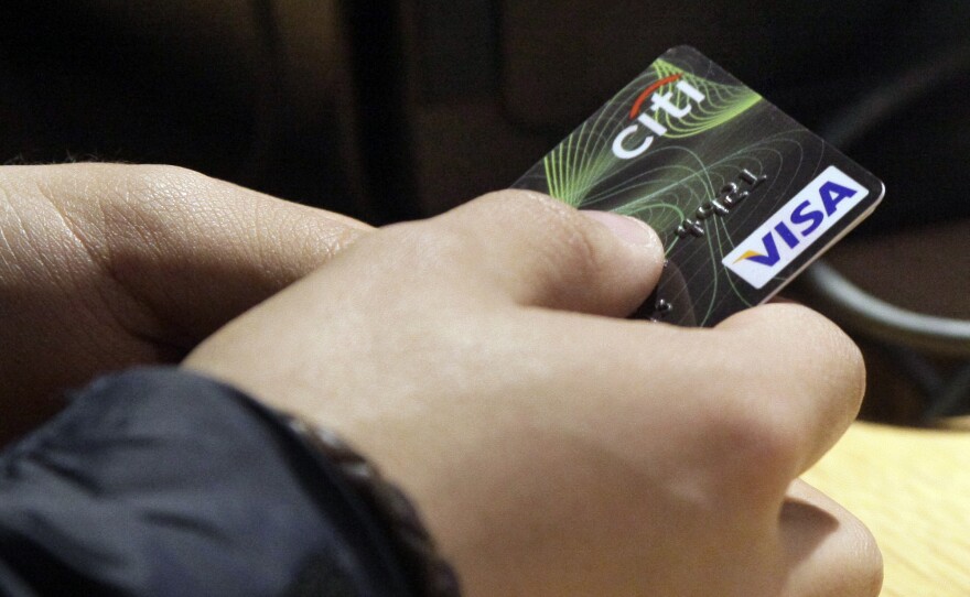 A person holding a credit card is shown in this undated photo. 