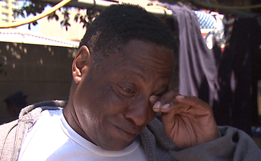 John Dumas, who is homeless, wipes away a tear while talking about violence against homeless San Diegans, July 6, 2016.