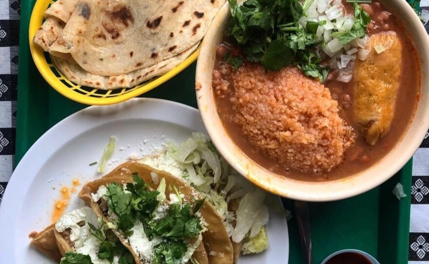 A plate of Mexican food from Las Cuatro Milpas is displayed on a green tray in this undated image.