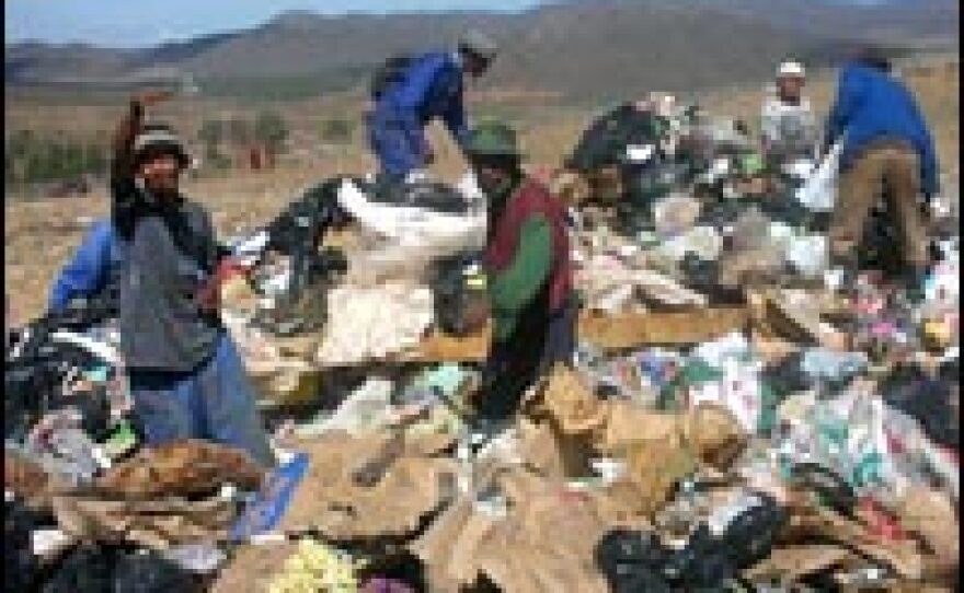 Unemployed residents of Zolani township scour a dump for scraps of food and items they can sell.