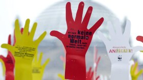 Placards inscribed with the words "Tackle climate change!" and other slogans stand near the Reichstag building in Berlin ahead of German Chancellor Angela Merkel's trip to Copenhagen.