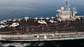 USS Nimitz Sailors and their families and friends spell out "NIMITZ" on the flight deck during the ship's 2010 Tiger Cruise.