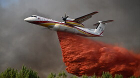 A plane releases fire retardant as it flies over a forest near Blagon, during wildfires in southwestern France, July 29, 2026.
