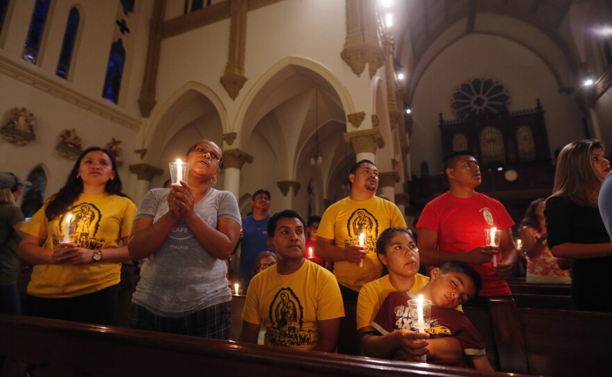 Worshipers participate in a "United To Heal Prayer Vigil" at Cathedral Guadalupe in Dallas on Friday, in honor of the police officers who were slain on Thursday.