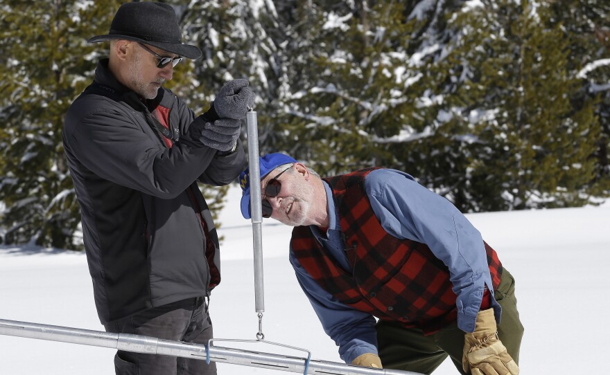 Frank Gehrke (right), California's chief snow surveyor checks the weight of the snowpack on a scale. Scientists say the snowpack is 185 percent of average, which is welcome news after the state's long drought.