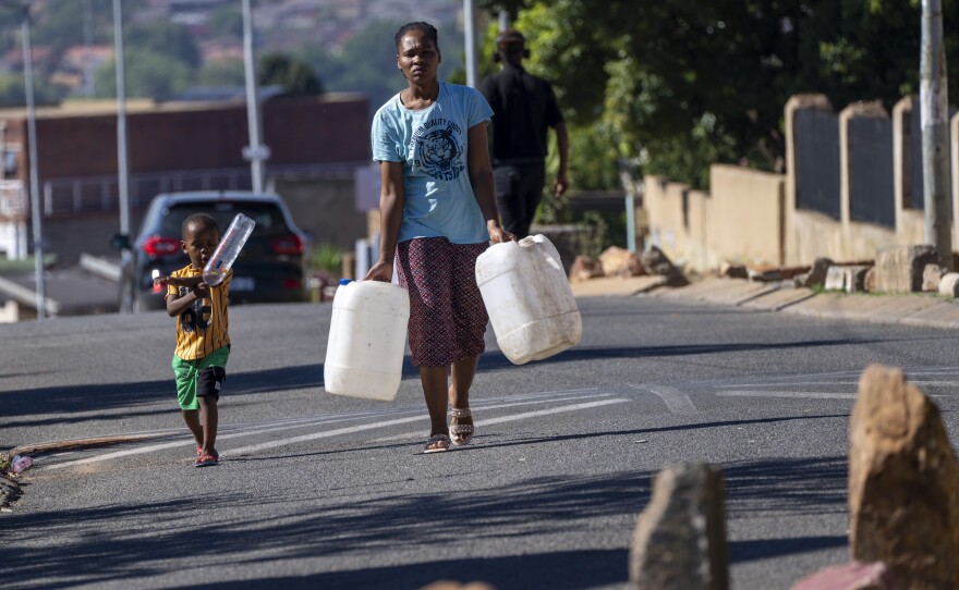 Soweto residents carry jugs and bottles to fill up with water, March 16.