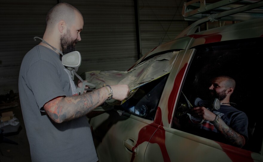 Neak removes the covering from the windows of a freshly painted truck.