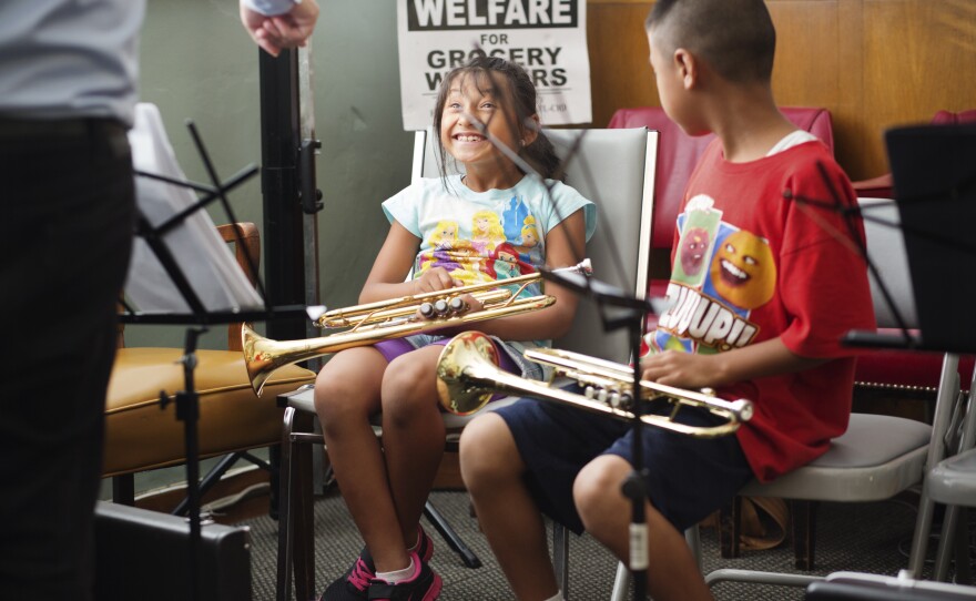 Trumpet teacher Danny Levin gets a laugh out of Katie Vela, left, and Andres Lopez, right, as he demonstrates what their chins should not be doing while playing.