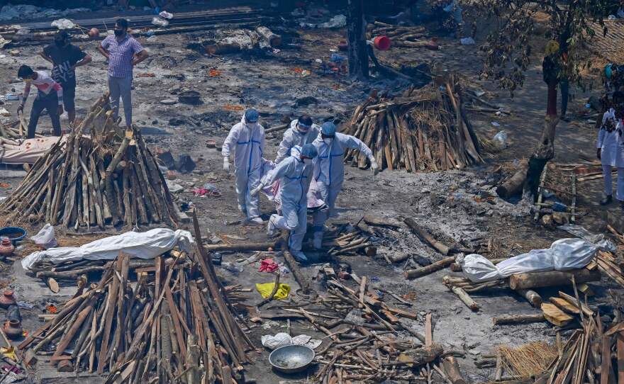 Relatives perform last rites amid funeral pyres during a mass cremation Tuesday at a New Delhi crematorium.