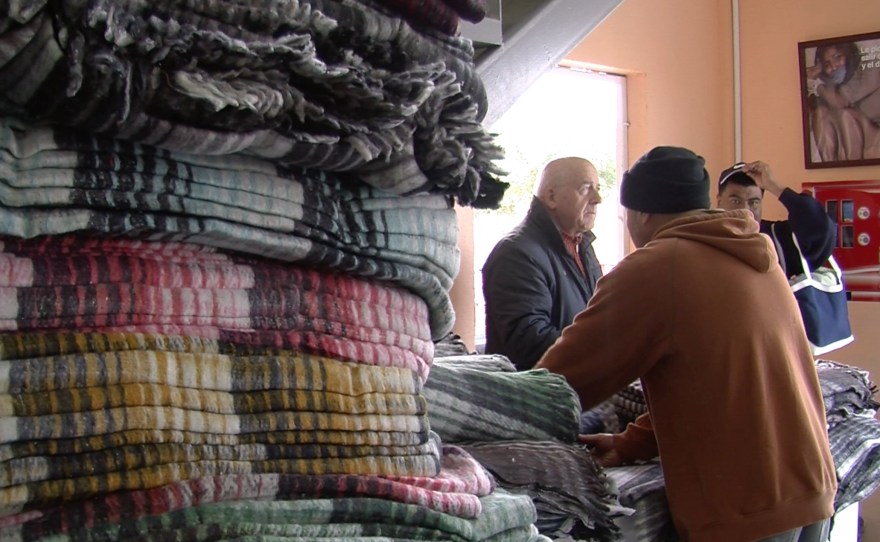Volunteers hand out blankets at Desayunador Salesiano, a Tijuana migrant shelter, Jan. 6, 2016.