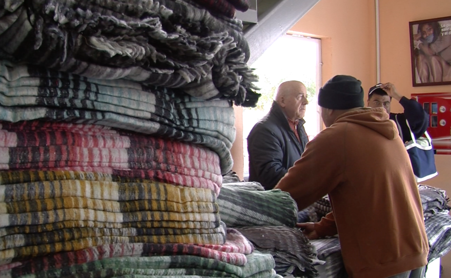 Volunteers hand out blankets at Desayunador Salesiano, a Tijuana migrant shelter, Jan. 6, 2016. 