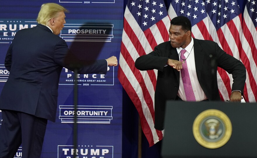 Then-President Donald Trump elbow bumps Herschel Walker during a 2020 campaign rally in Atlanta. Walker filed paperwork Tuesday to run for U.S. Senate in the key swing state of Georgia.