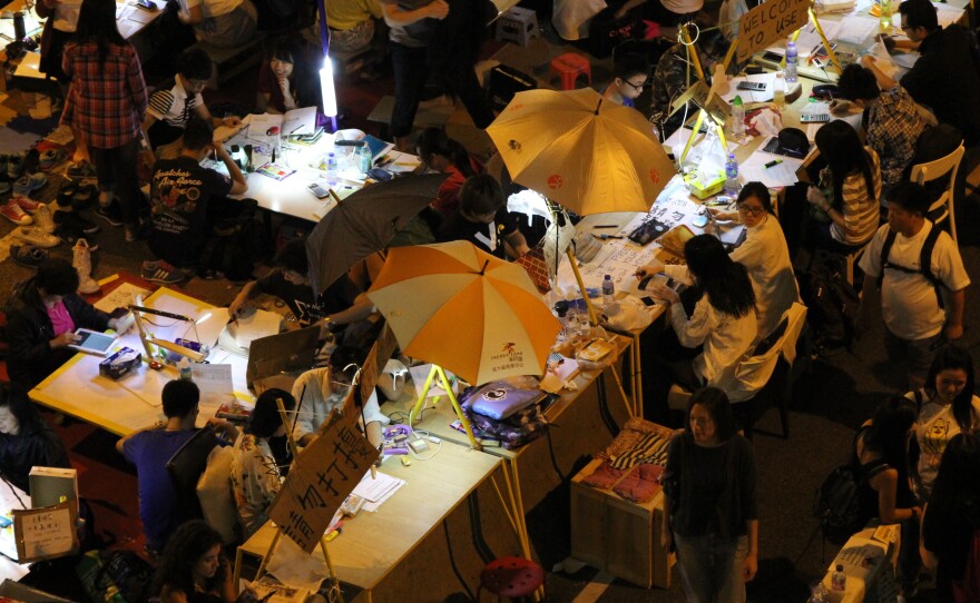 Student demonstrators don't want to fall behind on their studies, so volunteers built them an outdoor study hall. Some of the desks are built into the concrete highway divider.