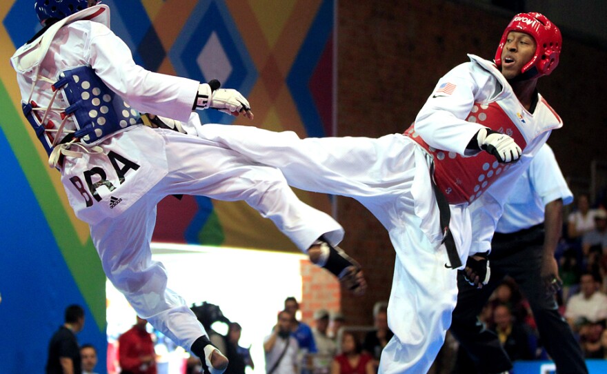 Terrence Jennings (right) lands a kick during a taekwondo match last fall. Jennings, who says his love of the <em>Teenage Mutant Ninja Turtles</em> drew him to the sport, will compete in his first Olympics this summer.