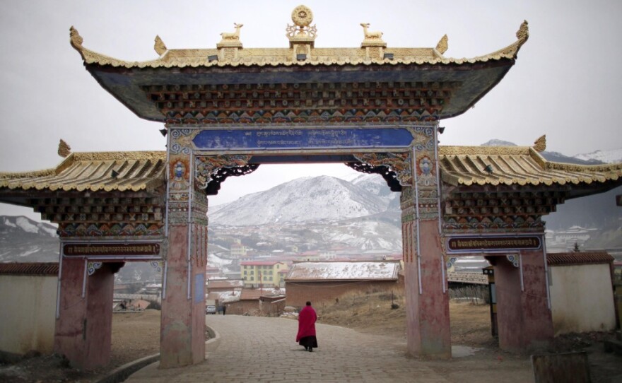 A monk walks under a temple entrance during Tibetan New Year celebrations in Langmusixiang, in China's western Sichuan Province Feb. 22, 2012.
