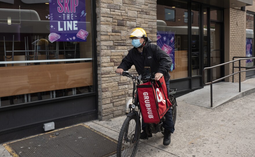 In this April 21, 2021 file photo, a delivery man bikes with a food bag from Grubhub in New York. The three biggest food delivery companies, DoorDash, Grubhub and Uber Eats, sued the City of New York in 2021 over its law to permanently limit the amount they can charge restaurants that use their services.