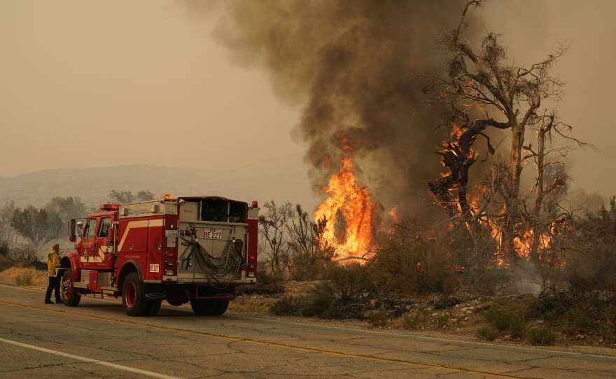 A San Bernardino County Fire Department member keeps an eye on a flareup from the Bobcat Fire in Valyermo, Calif. Saturday, Sept. 19, 2020.