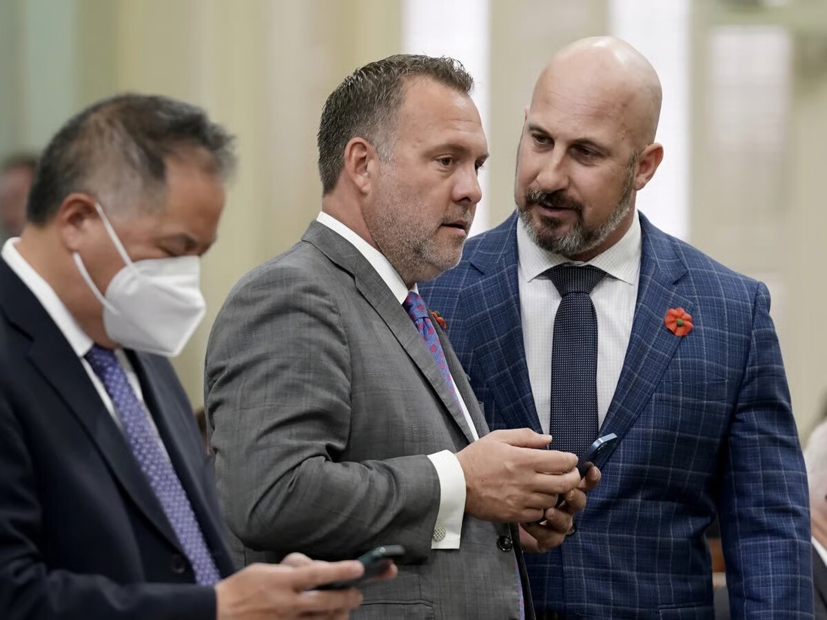 Central Valley Assembly members, Democrat Adam Gray, of Merced, center, and Republican Heath Flora of Ripon, right, confer during the Assembly session at the Capitol in Sacramento, Calif., May 27, 2022.