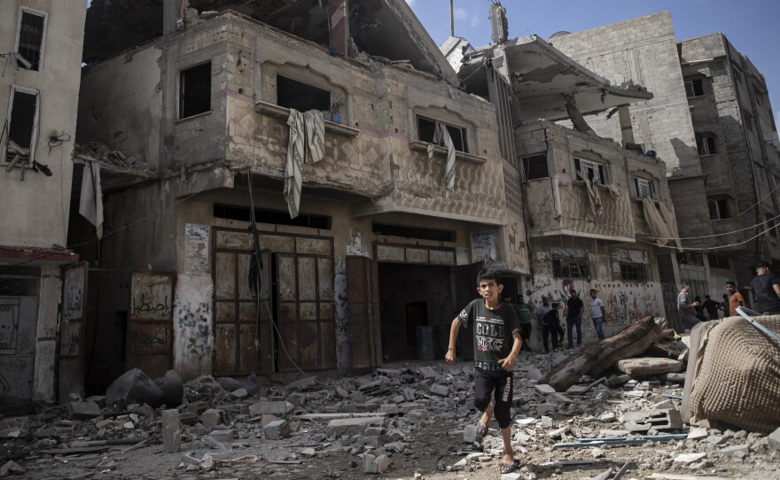Palestinians inspect damaged houses that were hit in Israeli airstrikes in Gaza City early Monday.