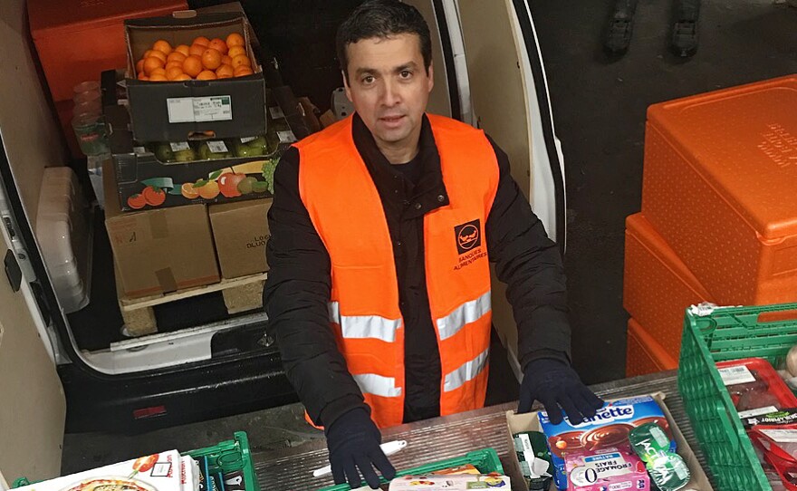 Djerbrani checks a selection of food to be donated from a French grocery store.
