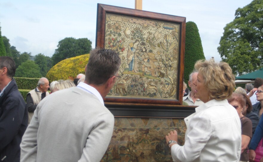 Hilary Kay inspects two pieces of Stuart embroidery.