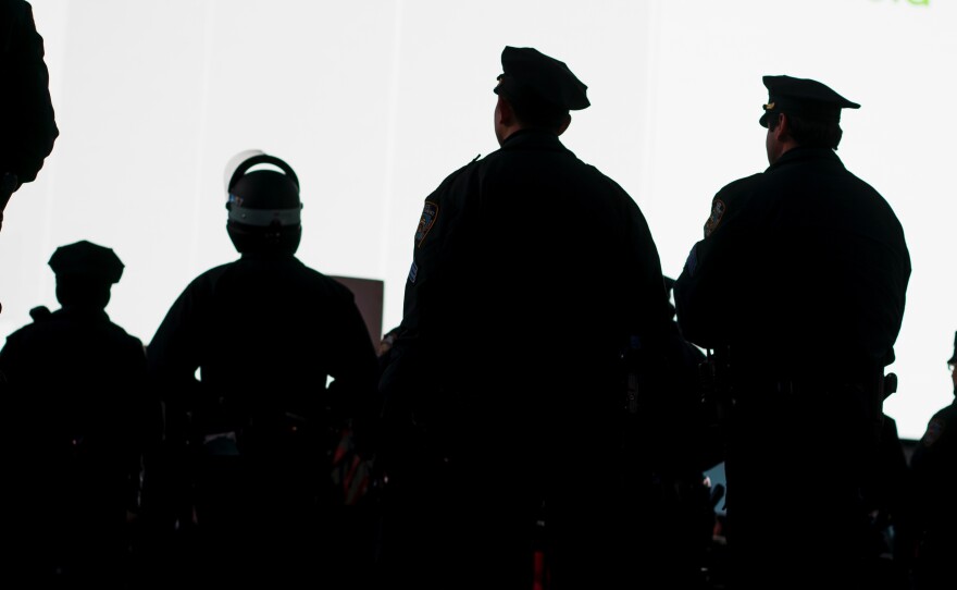 New York City Police officers watch demonstrators protesting the death of Eric Garner near Times Square.