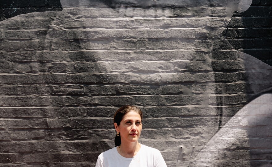 Neda Sharghi stands in front of a mural of her brother Emad. "I'm so scared I'm never going to see my brother again," she says.