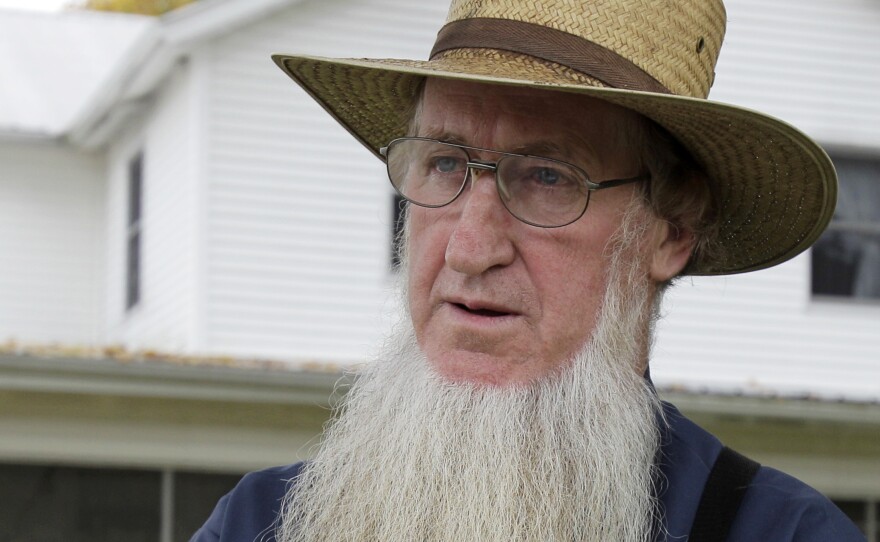In this Oct. 10, 2011 file photo, Sam Mullet stands in the front yard of his home in Bergholz, Ohio. Mullet's conviction for hate crimes for cutting the hair and beards of fellow members of his faith was overturned Wednesday.