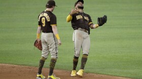 San Diego Padres' Jake Cronenworth (9) and Fernando Tatis Jr., right, celebrate after their 6-4 win against the Texas Rangers in a baseball game in Arlington, Texas, Tuesday, Aug. 18, 2020. 
