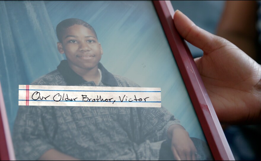 Reneasha Jacobs holds a photograph of her and James' older brother, Victor Benjamin. Benjamin was shot and killed on April 19, 2004.
