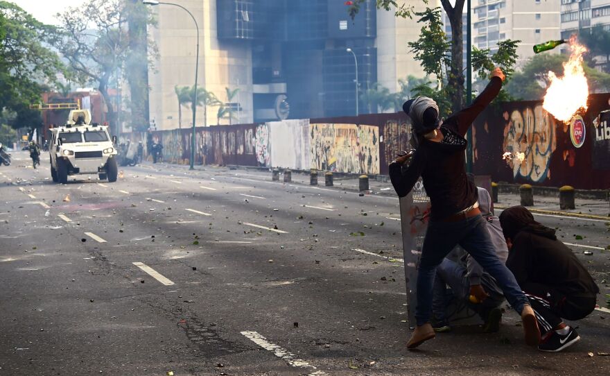 Demonstrators hurl flaming objects at riot police during the anti-Maduro rally in Caracas.
