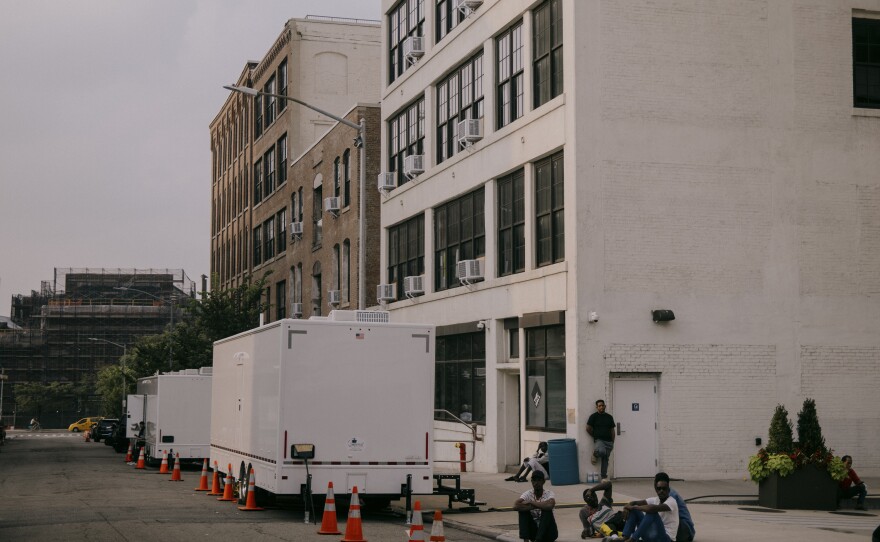 Asylum-seekers spill out onto Hall Street outside the Clinton Hill Shelter. Two shower units stand outside at 47 Hall St. in Brooklyn on July 19.