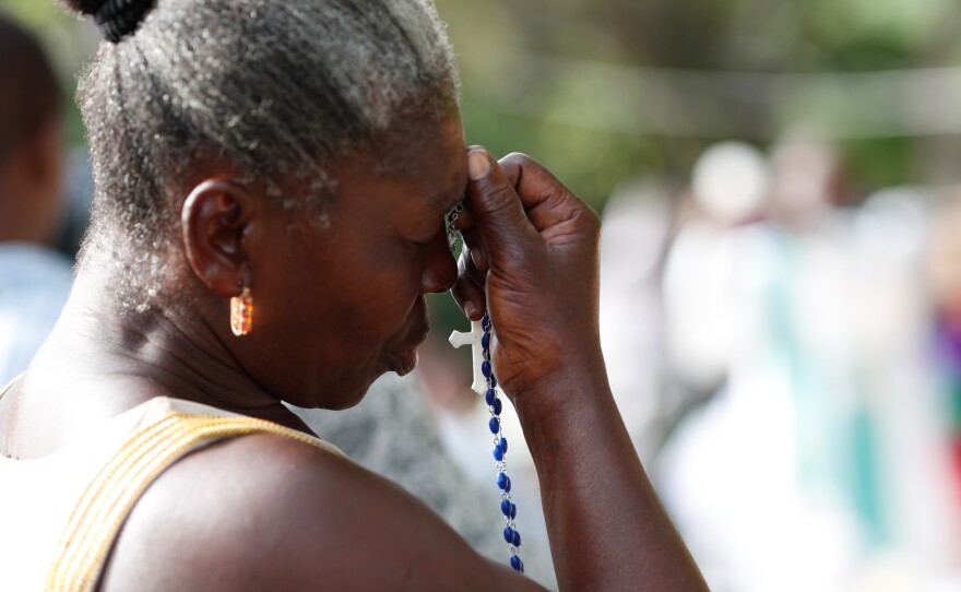 A woman prays near the ruins of Sainte-Agnes Catholic Church.
